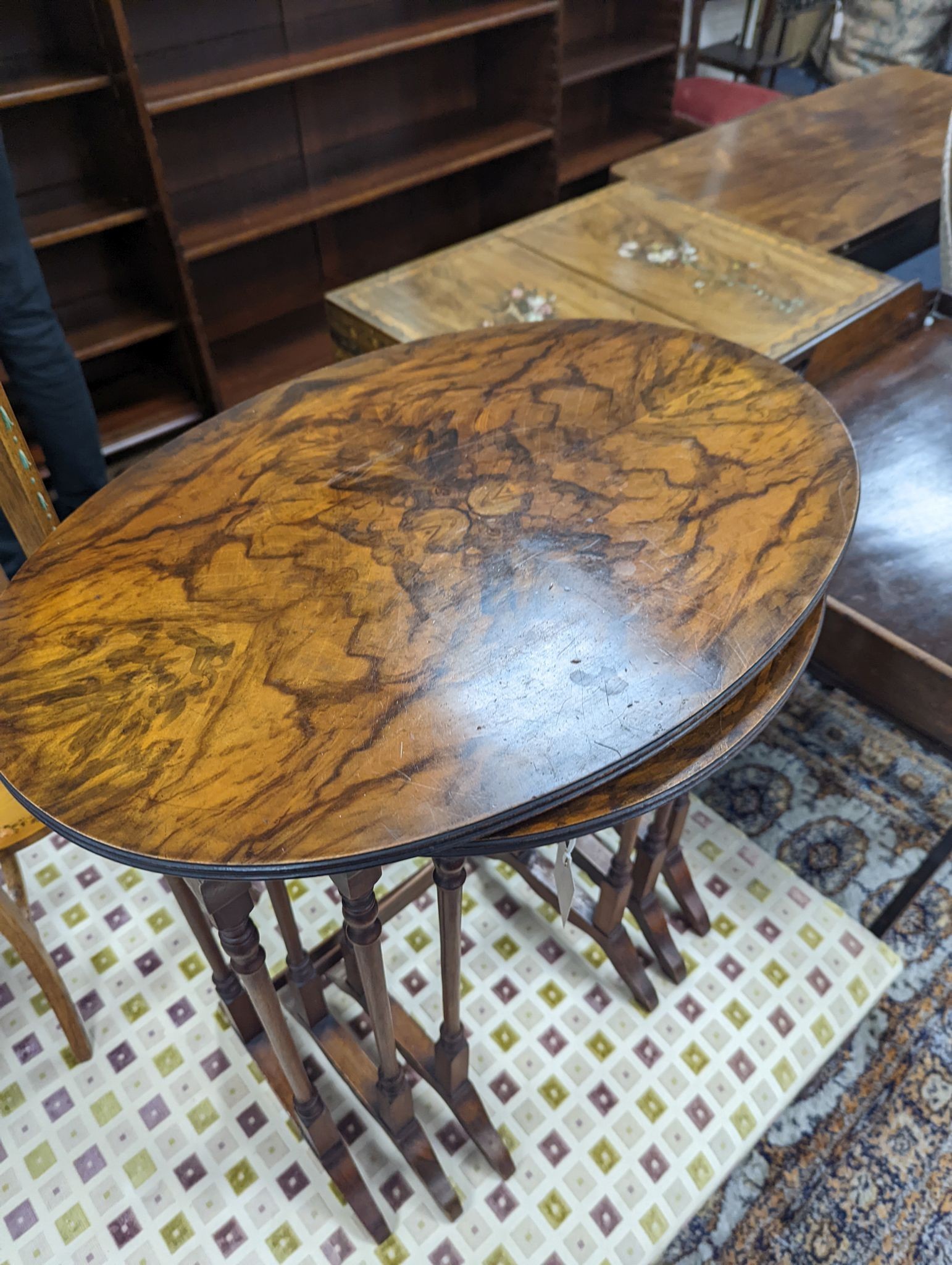 A nest of three oval and circular burr and simulated walnut tea tables, width 55cm, depth 37cm, height 60cm